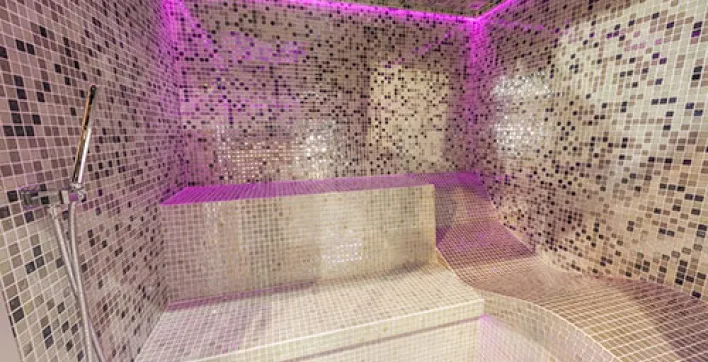 Une cabine de hammam très bien équipée et entièrement carrelée de mosaïque