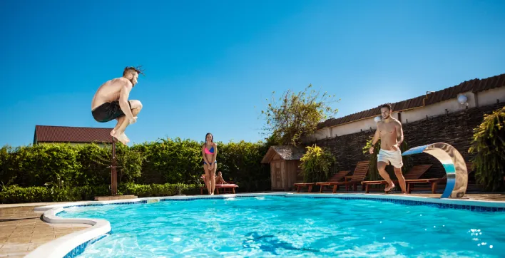 Des jeunes faisant une bombe dans une piscine