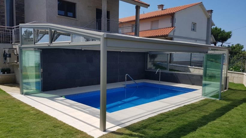 Un abri de piscine haut adossé à une maison