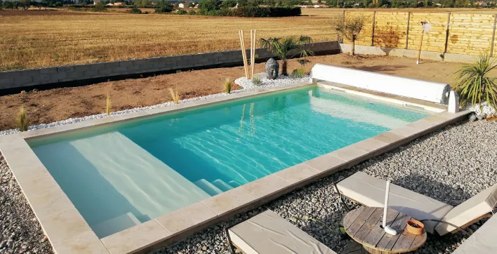 La piscine coque familiale avec plage dans l’eau de Génération Piscine