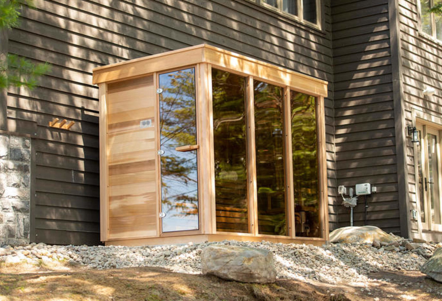 Un sauna d'extérieur avec de grands panneaux vitrés 