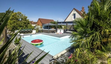 Photo d'une piscine Aquilus et d'un spa familial dans un jardin luxuriant à Bourges, transformé en havre de paix