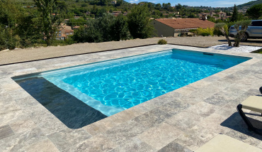 Une piscine coque avec volet automatique sous plage signée Piscines Ibiza