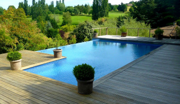 Une structure monobloc avec escalier, parois et fond pour cette piscine à débordement signée UNIBEO