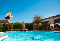 Des jeunes faisant une bombe dans une piscine